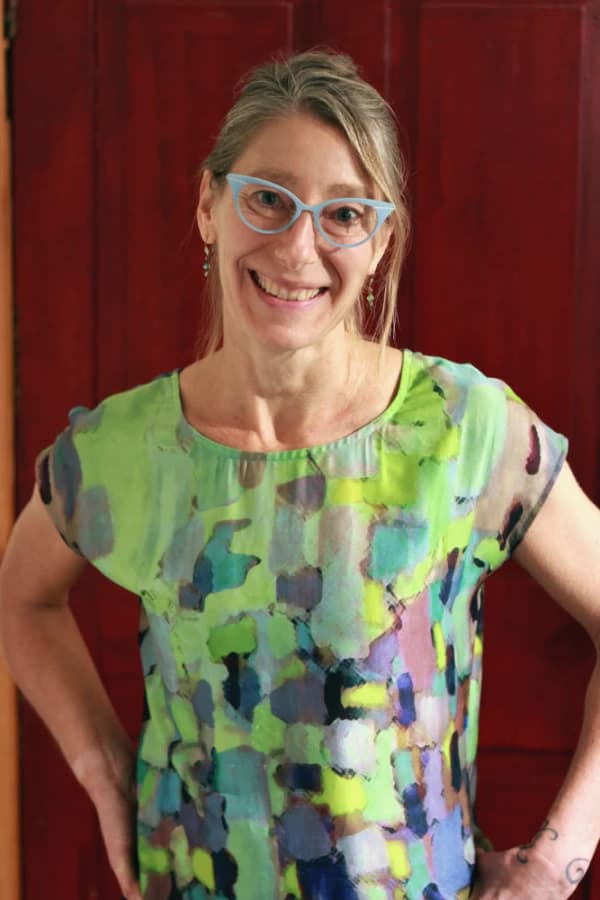 Jen Helmuth standing in front of a red door in her office